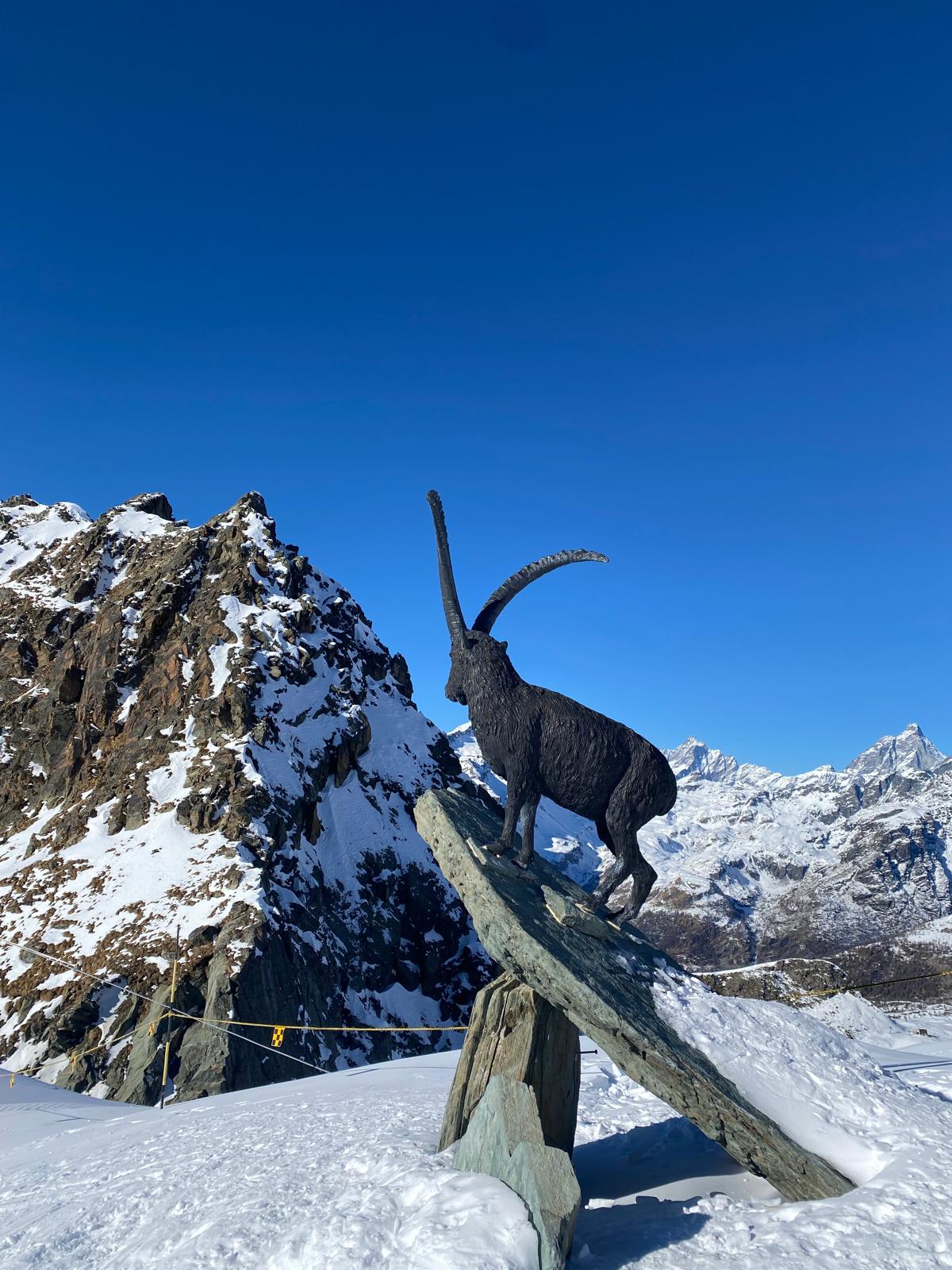 Locandina weekend a Gressoney, con una statua di un ariete e sullo sfondo le montagne.